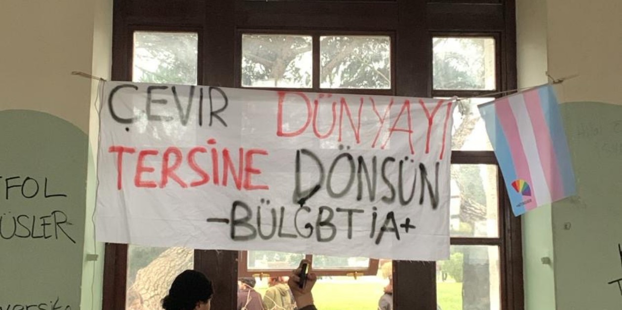 ÖFB ablukası yıkıldı: 2021’de odası kapatılan BÜLGBTİ+ pankartıyla alanda, forum saatini bekliyor - ÜniKuir